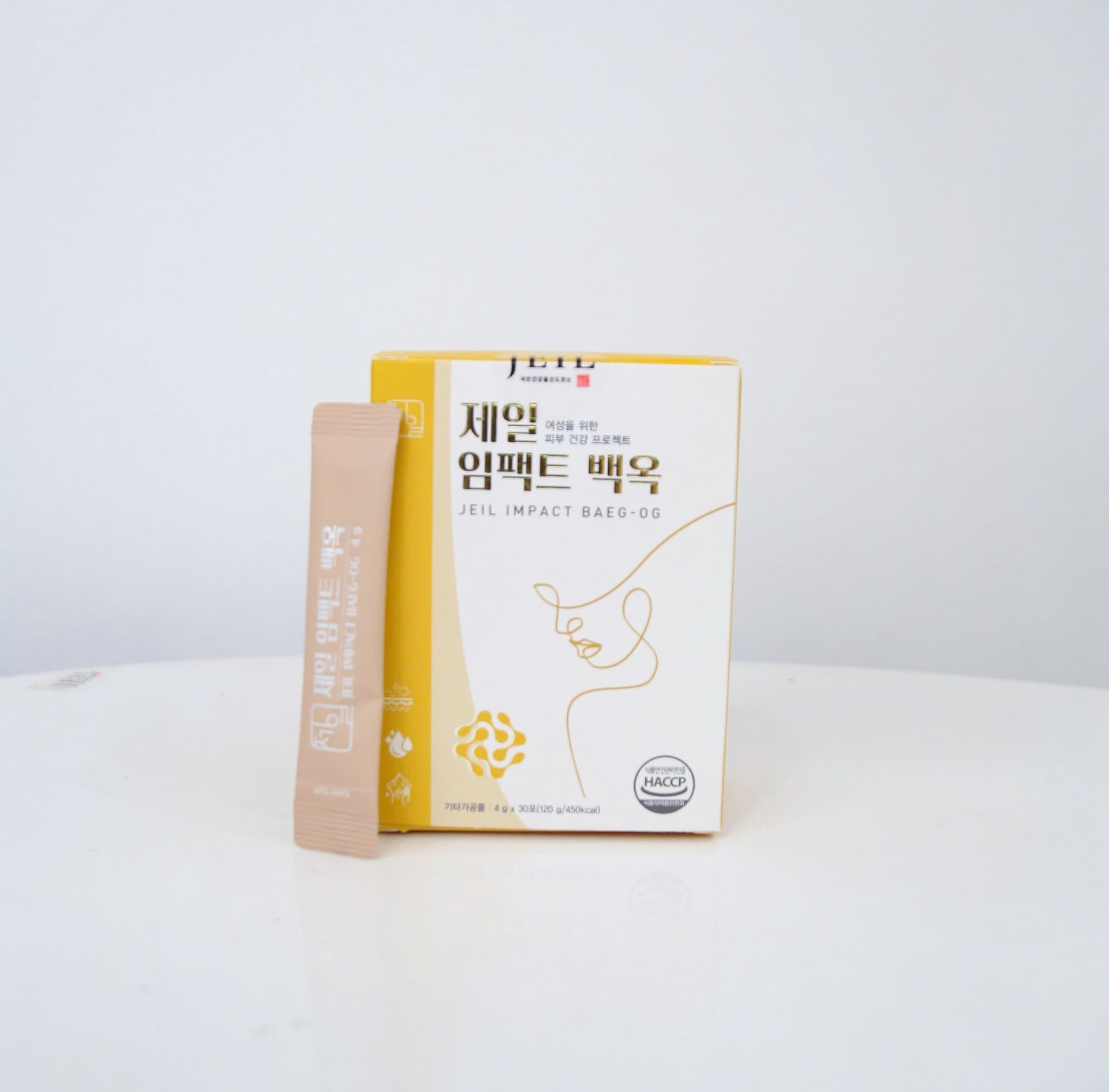 Box and sachet of Jeil Impact Baeg-Og skincare product on a white surface.