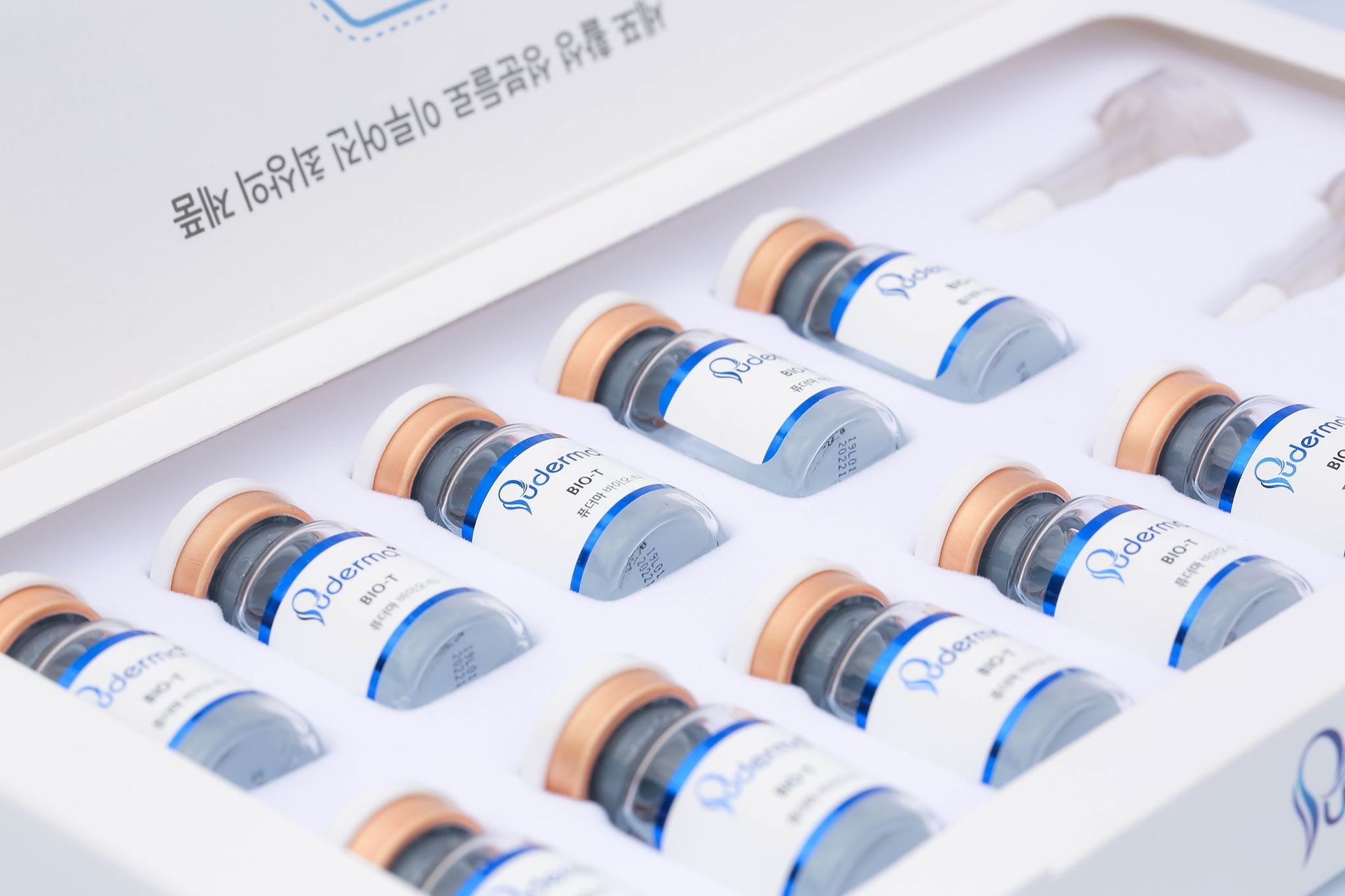 Box of skincare ampoules with labels, arranged neatly in a tray.