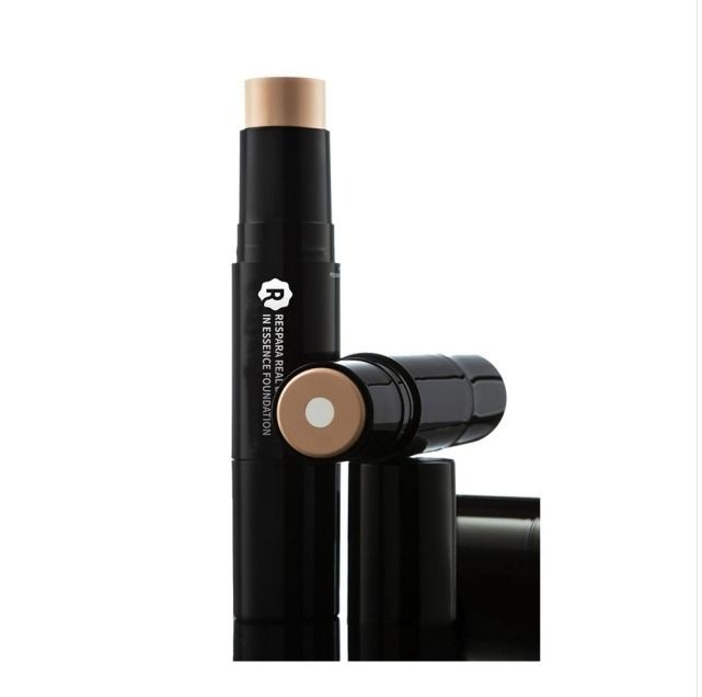 Tube of essence foundation with beige stick, featuring a sleek black container and branding on the side.