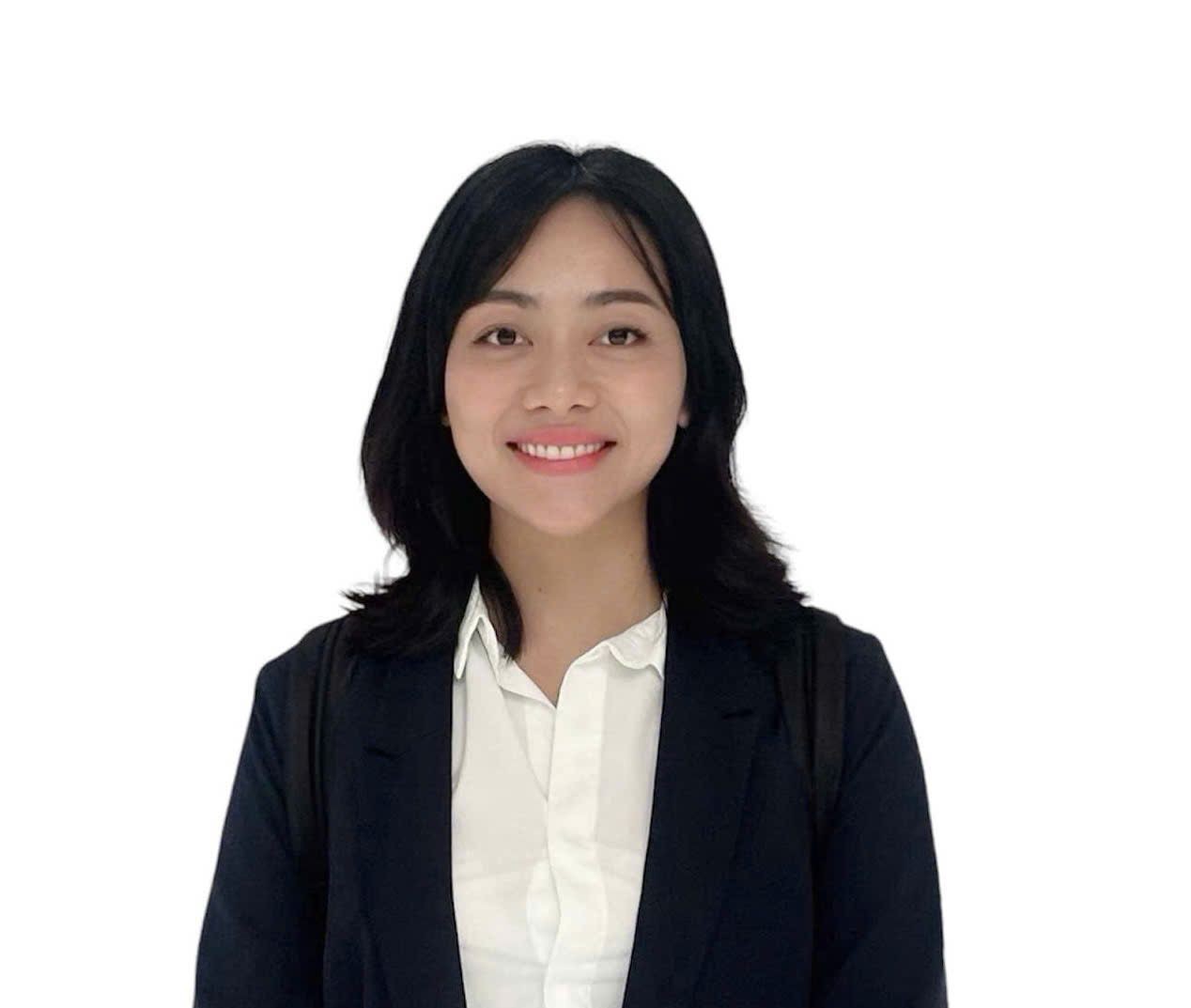 Smiling woman in a suit with a white background.