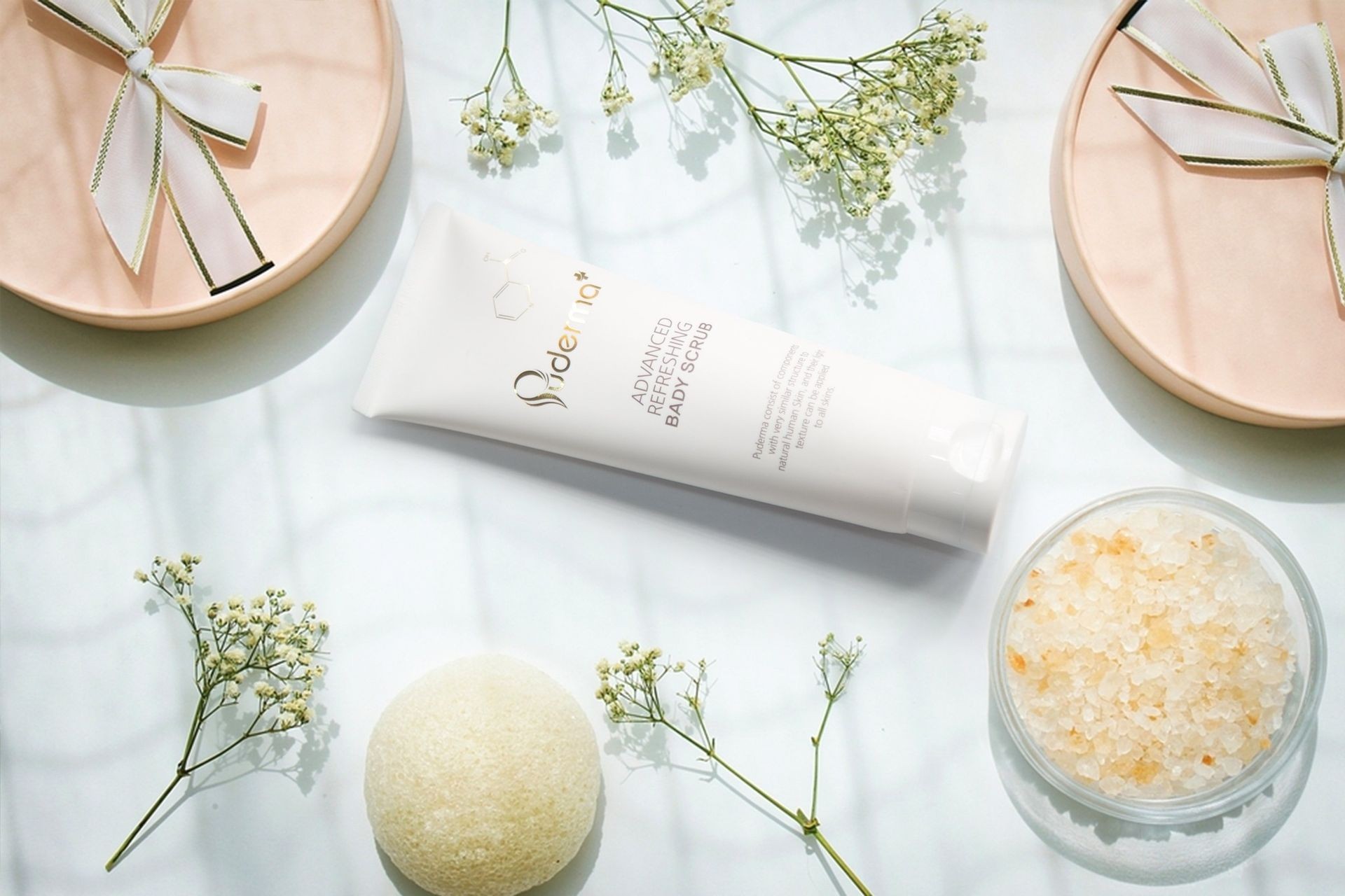 Skincare products with floral accents and bath salts on a white surface.