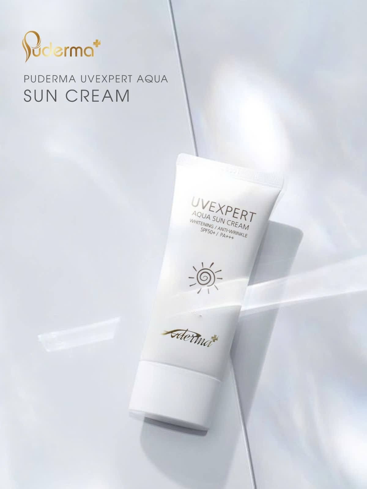 Tube of Puderma UV Expert Aqua Sun Cream on a reflective surface.